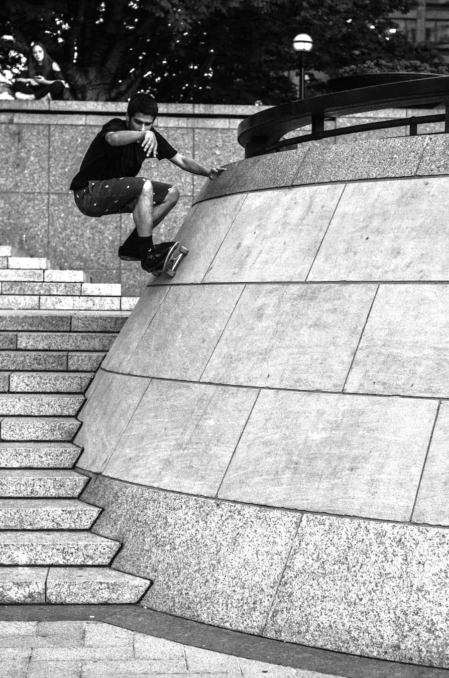 Nuno Ramirez frontside wallride at Canary Wharf, London. Black and white skate photo by Chris Morgan, focused on form, texture, and contrast.